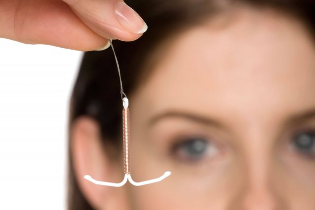 Eine Frau hält eine Kupferspirale zwischen den Fingern