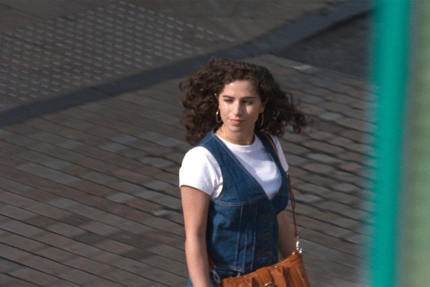 Frau in Jeanskleid die eine Straße überquert