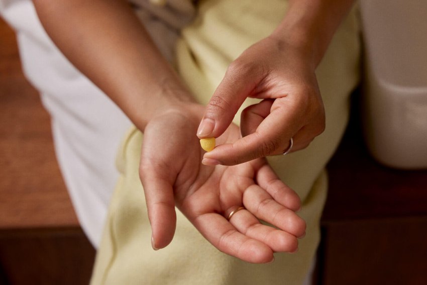 Hände halten die ellaone pille in form eines schildes